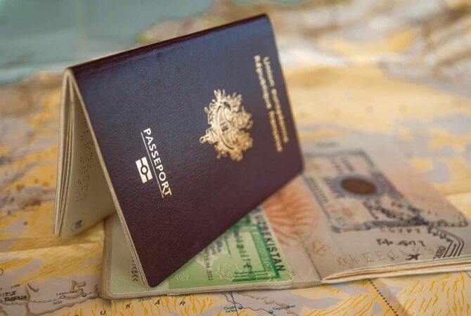 Un passeport français ouvert, révélant un visa pour l'Ouzbékistan, posé sur une carte géographique avec l'inscription Passeport en évidence.